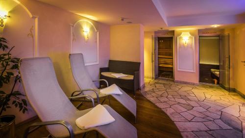 a waiting room with chairs and a table and a room at Hotel Armin in Selva di Val Gardena