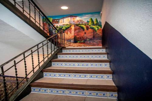 a staircase with a painting on the wall at Hostal Viena Plaza Nueva in Granada