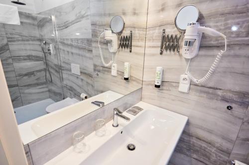 a bathroom with a sink and a shower and a mirror at Hotel Garden Court in Prague