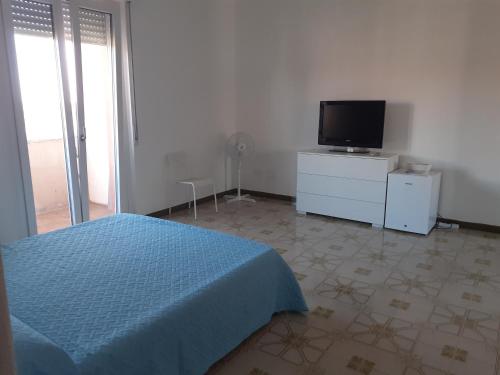 Schlafzimmer mit einem Bett und einem Flachbild-TV in der Unterkunft Casa di Andy in Cagliari