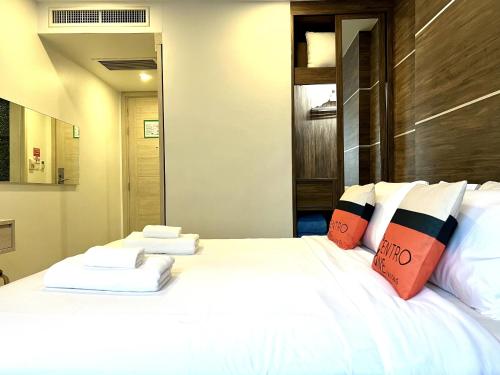 una camera da letto con un grande letto bianco con cuscini di Centro One Bangla a Patong Beach