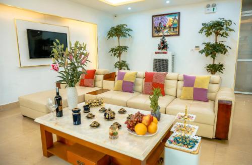 a living room with a couch and a table with fruit on it at Aloha Hotel in Hanoi