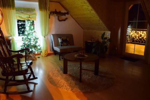 a living room with a christmas tree and a table at Apartment Sotočje in Dolenja Trebuša