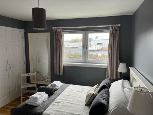 a bedroom with a large bed and a window at Flat Three, 212 Eaglesham Road, East Kilbride, Glasgow in East Kilbride