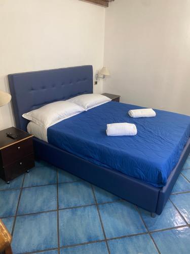 una camera da letto con un letto blu con due asciugamani di B&B Riviera a Napoli