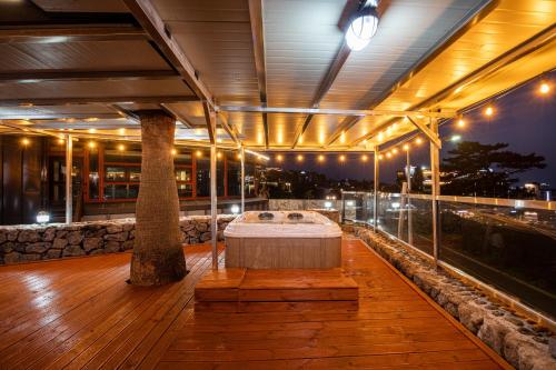 a room with a bed on the deck of a building at Aewol Oceanstay in Jeju