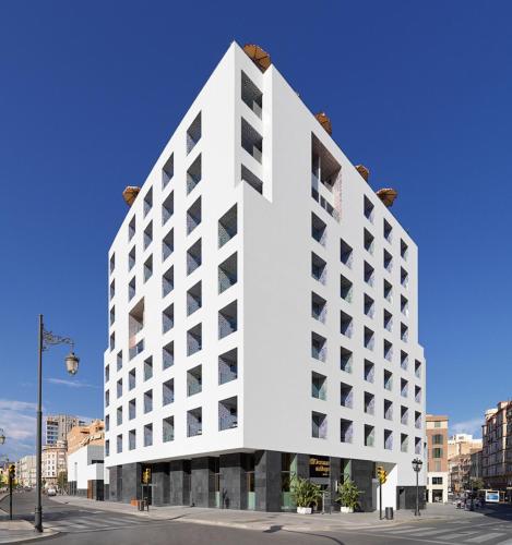a white building on the corner of a street at H10 Croma Málaga in Málaga