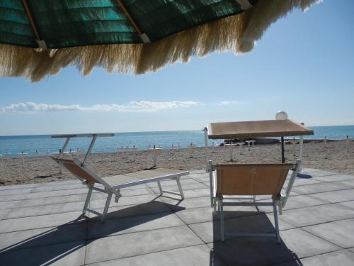a table and chairs on a beach with a piano at Lillananna Reload in Porto SantʼElpidio