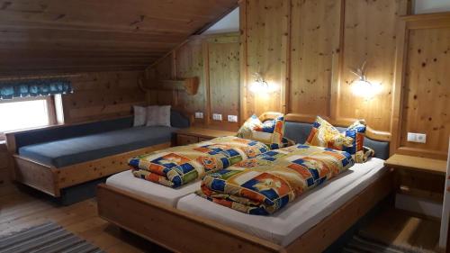 ein Schlafzimmer mit 2 Betten und einem Sofa in einer Hütte in der Unterkunft Sieglhof in Breitenbach am Inn