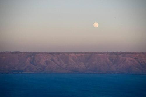 a large body of water with a mountain in the background at Sea of Galilee Tiberius apartment with panoramic sea view in Tiberias