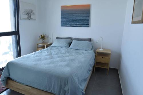 a bedroom with a bed and a table with a night stand at Sea of Galilee Tiberius apartment with panoramic sea view in Tiberias