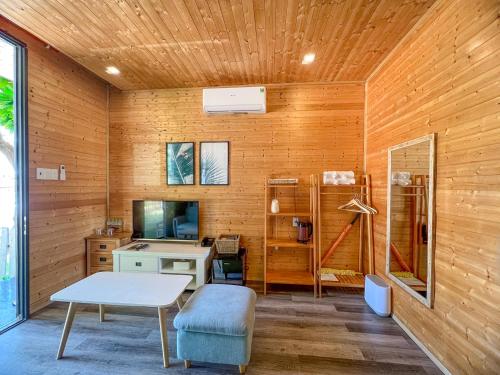 a room with wooden walls and a desk and a table at Long Hải Channel Beach Resort in Long Hai