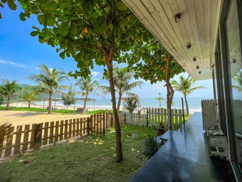 a house with a fence and a tree on the beach at Long Hải Channel Beach Resort in Long Hai