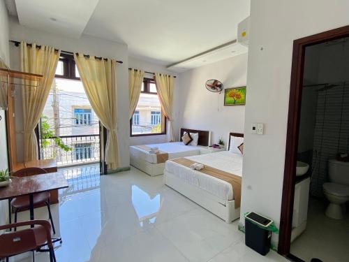een slaapkamer met 2 bedden en een balkon bij Bui Family Homestay in Hội An