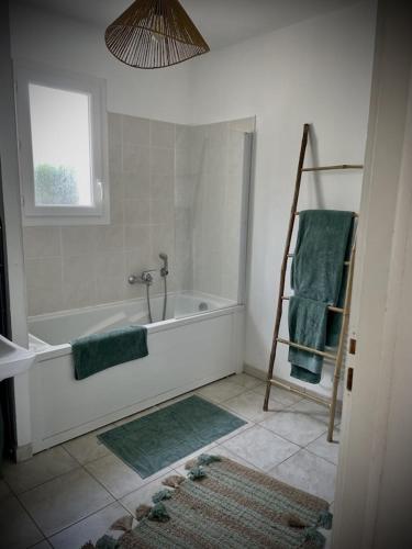 La salle de bains est pourvue d'une baignoire et d'une serviette verte. dans l'établissement La Casetta Prunette, à Cervione