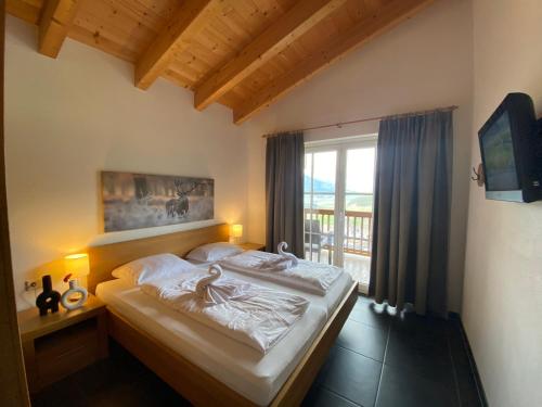 a bedroom with a bed and a large window at Chalet an der Piste in Kaprun