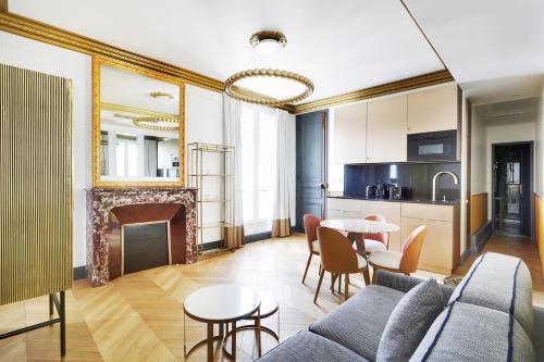 a living room with a fireplace and a table and chairs at Pick A Flat's Apartments in Champs Elysées - Rue du Colisée in Paris