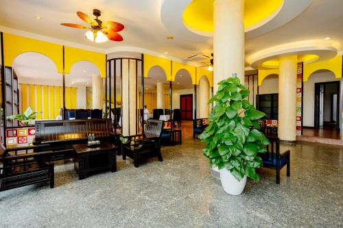 a lobby with a piano and a living room at Sea and Sand Hotel in Hoi An