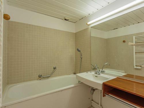 une salle de bain avec un lavabo, une baignoire et un miroir dans l'établissement Studio Front de Mer avec Piscine et Balcon à Biarritz - FR-1-3-412, à Biarritz