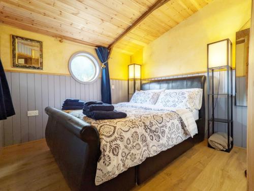 a bedroom with a bed in a room with a window at The Quail Cabin in Kirdford