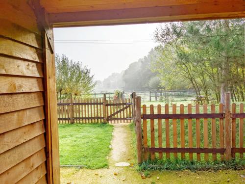 a gate to a fence with a field behind it at The Quail Cabin in Kirdford