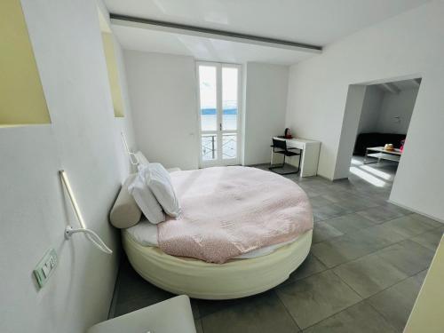 ein Schlafzimmer mit einem runden Bett in einem Zimmer mit einem Fenster in der Unterkunft boat house facing the lake in Orta San Giulio
