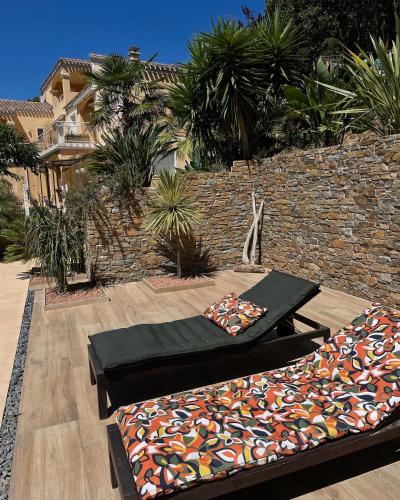 a patio with two beds and a wall at Villa U Tramontu in Granace