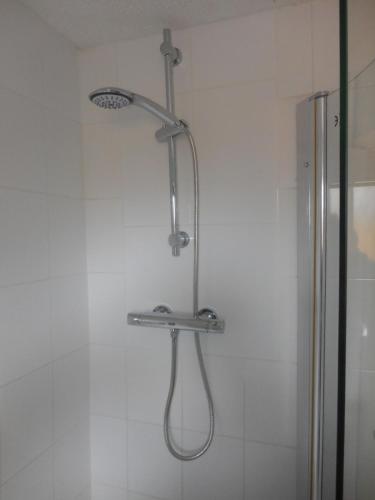 a shower with a shower head in a bathroom at Rose Bungalow In Carlton Colville in Pakefield