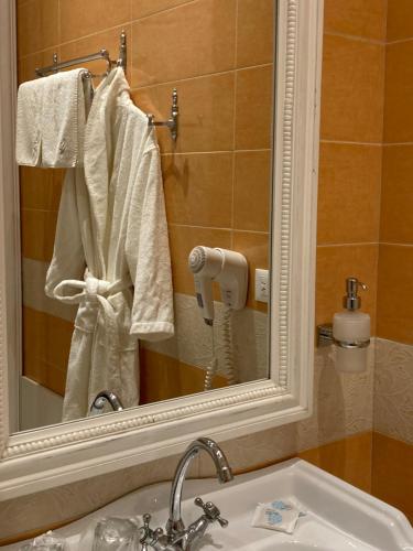 a bathroom with a sink and a mirror and towels at Boutique Hotel Anagennisis in Pýrgos