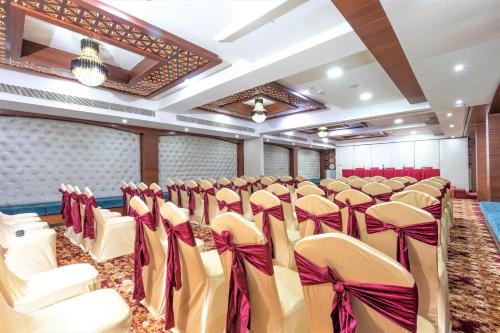 a room with rows of chairs with bows at The Saibaba Hotel in Chennai