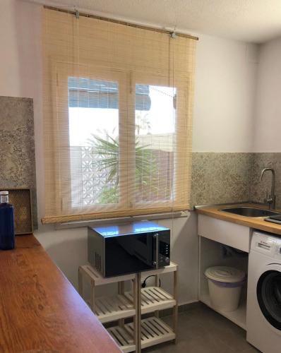 a kitchen with a sink and a microwave at Casa Alejandro Las Vistas in Arona