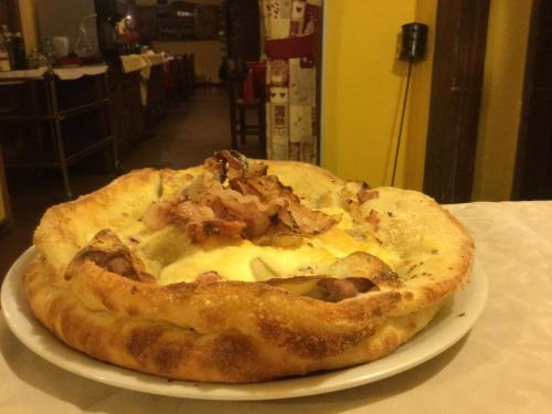 a pizza sitting on a plate on a table at Hotel Etoile De Neige in Valtournenche