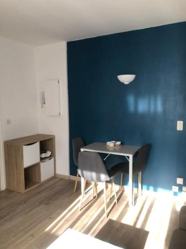 a dining room with a blue wall and a table and chairs at Joli studio centre-ville Draguignan in Draguignan