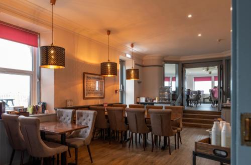 um restaurante com mesas e cadeiras e um bar em GOLF View Hotel & Macintosh Restaurant em Lossiemouth