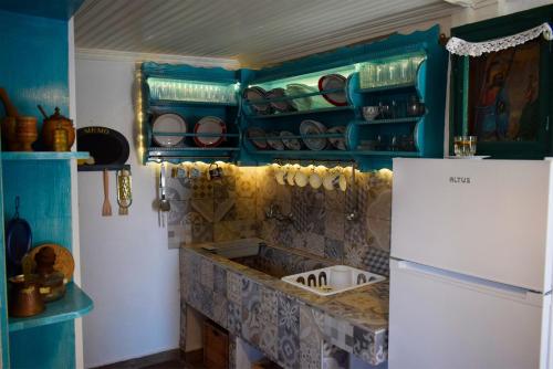 a kitchen with blue walls and a white refrigerator at Renovated Old Manor House With Yard in Arnaia