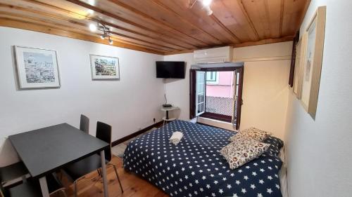 a small bedroom with a bed and a desk at Casa em Alfama in Lisbon