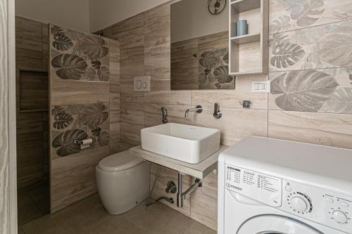a bathroom with a sink and a washing machine at Resort Almaredamarra con piscina e idromassaggio sul mare in Torre San Giovanni Ugento
