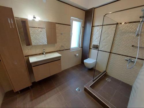 y baño con lavabo, ducha y aseo. en Elegant View - Trikala - 3BD Apt, en Tríkala