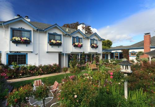 a house with a garden with chairs and flowers at Mill Rose Inn in Half Moon Bay
