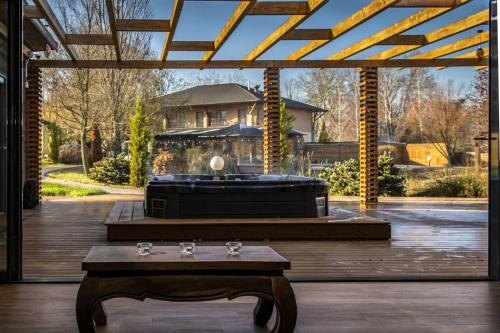 a large patio with a hot tub and a table at Session Hotel Ráckeve in Ráckeve