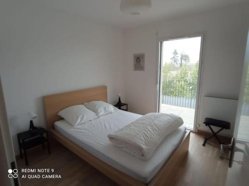スノンにあるSuperbe appartement avec balcon filantのベッドルーム1室(ベッド1台付)、スライド式ガラスドアが備わります。