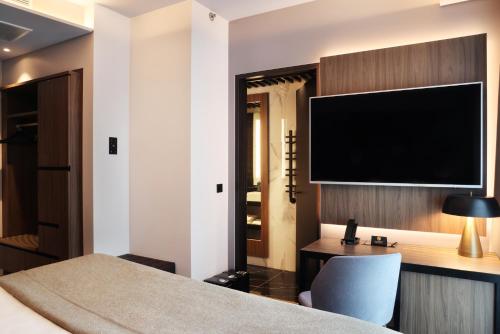 a hotel room with a bed and a flat screen tv at Hotel Reykjavík Saga in Reykjavík