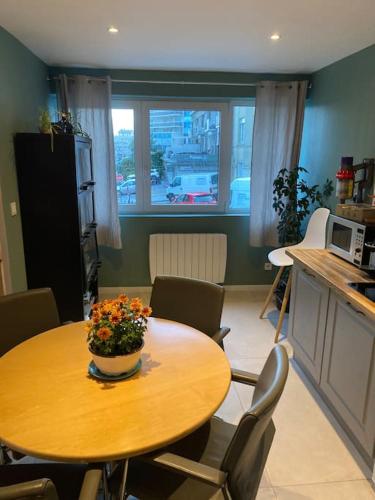 - une cuisine avec une table et un bol de fleurs dans l'établissement Au coeur de boulogne sur mer, à Boulogne-sur-Mer