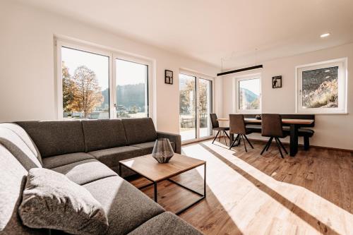 a living room with a couch and a table at Tanners Chalet Apartments in Altenmarkt im Pongau