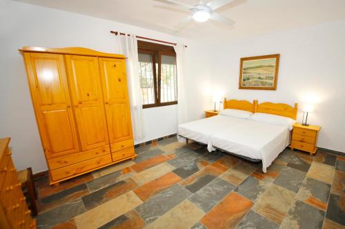 1 dormitorio con 1 cama y armario de madera en Senia Tomaset III, en Onil