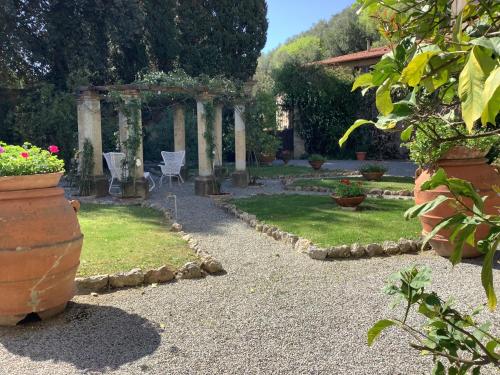 a garden with a pergola and a table and chairs at Villa Rita in Vicopisano