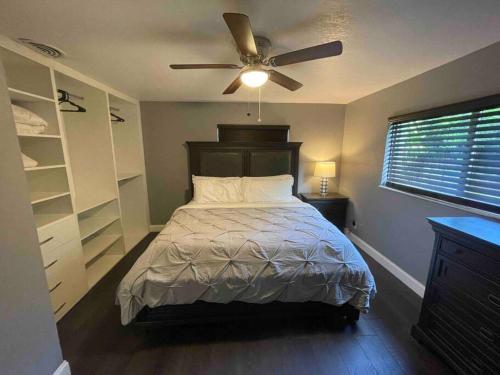 a bedroom with a bed with a ceiling fan at Beautiful, quiet & cozy home near Lake Worth Beach in Lake Worth