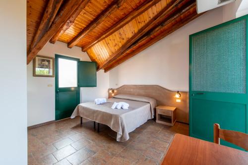 een slaapkamer met een bed en een tafel in een kamer bij Villaggio Alkantara in Giardini Naxos