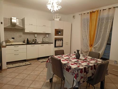 een keuken met een tafel met een tafelkleed erop bij Appartamento nel cuore delle Alpi in Susa
