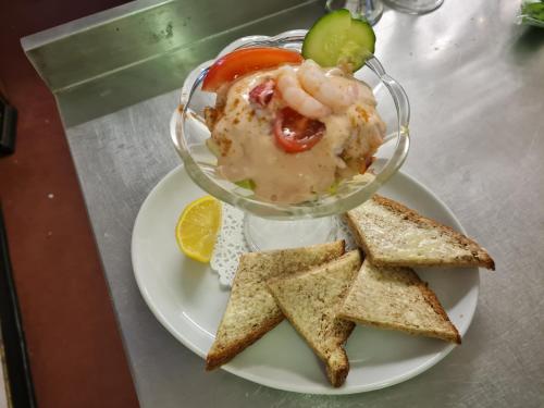 a plate with a bowl of food with shrimp and crackers at The Crown Hotel in Inverbervie